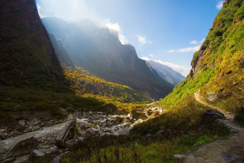 Sunlit glacial valley and trail near Deurali on the Annapurna Base Camp route