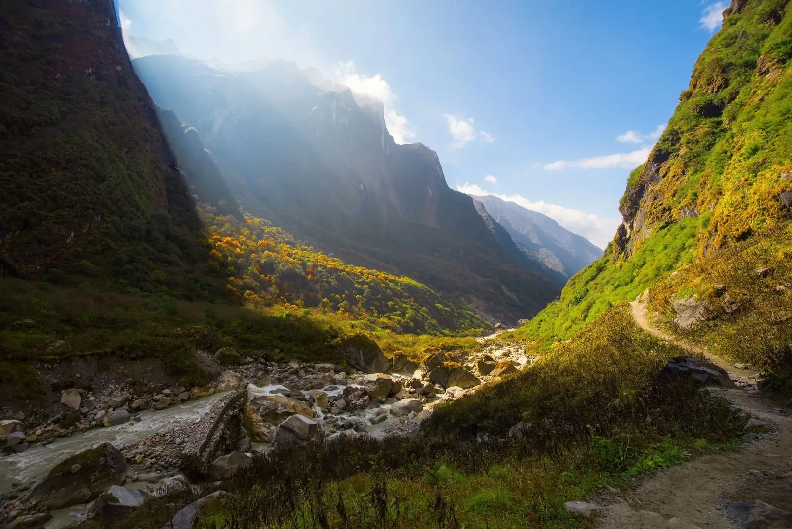 Sunlit glacial valley and trail near Deurali on the Annapurna Base Camp route