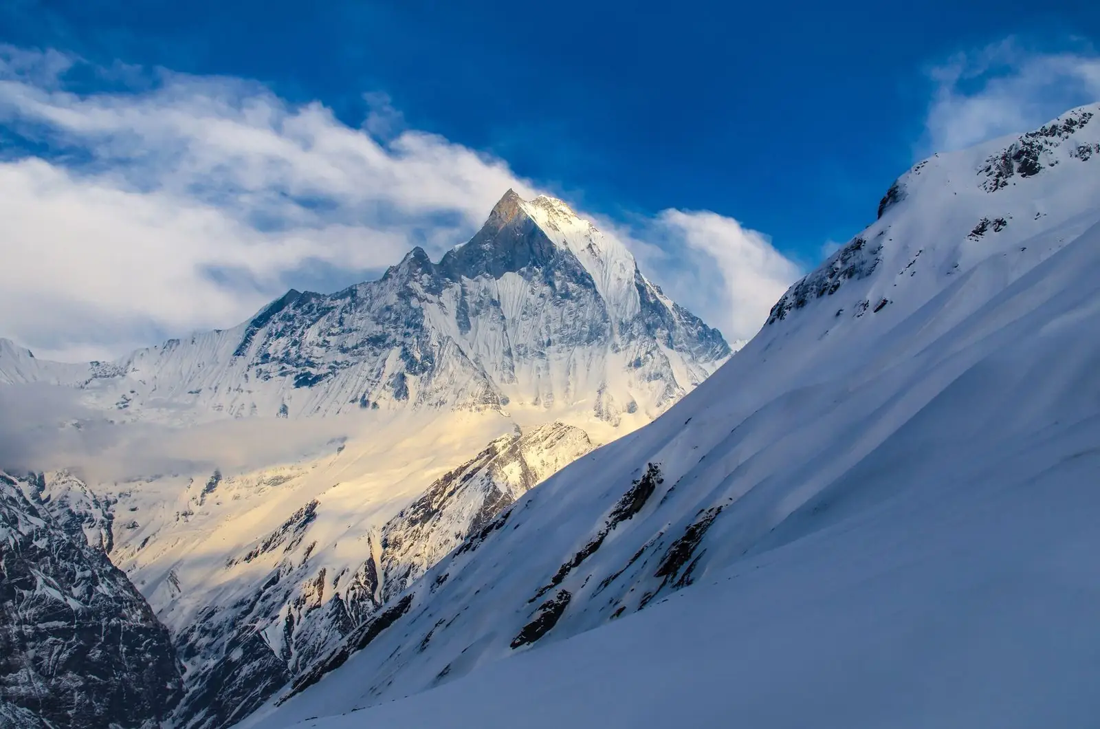 Machapuchare, the Fishtail peak, above a snowy ridge