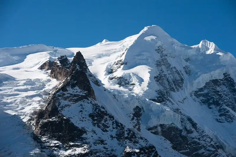 Glaciated summit with a rock spire in the high Himalaya