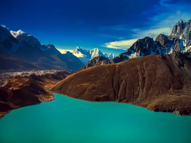 Turquoise Gokyo Lake below brown moraine slopes