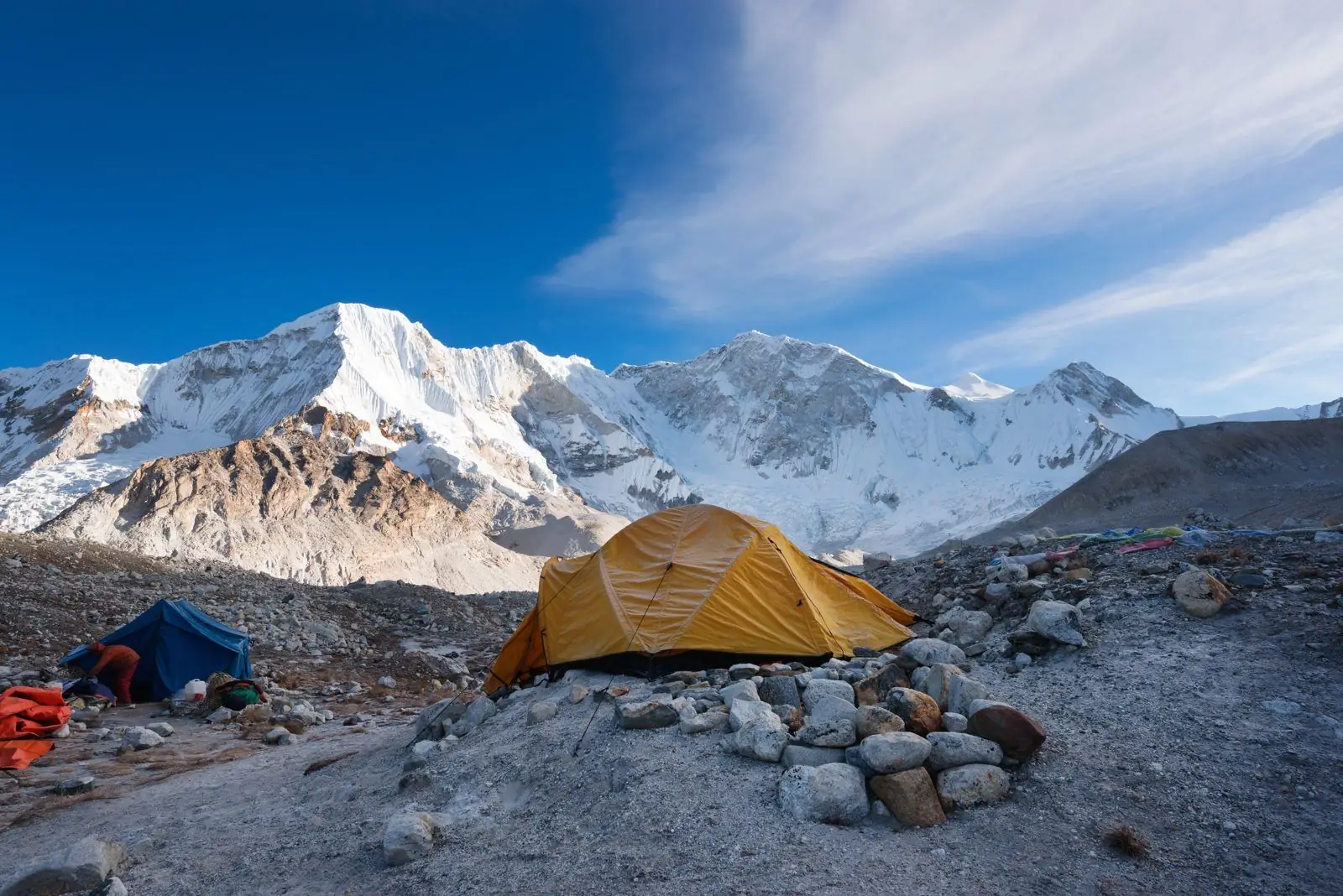 Tents pitched at a high camp below glaciated peaks