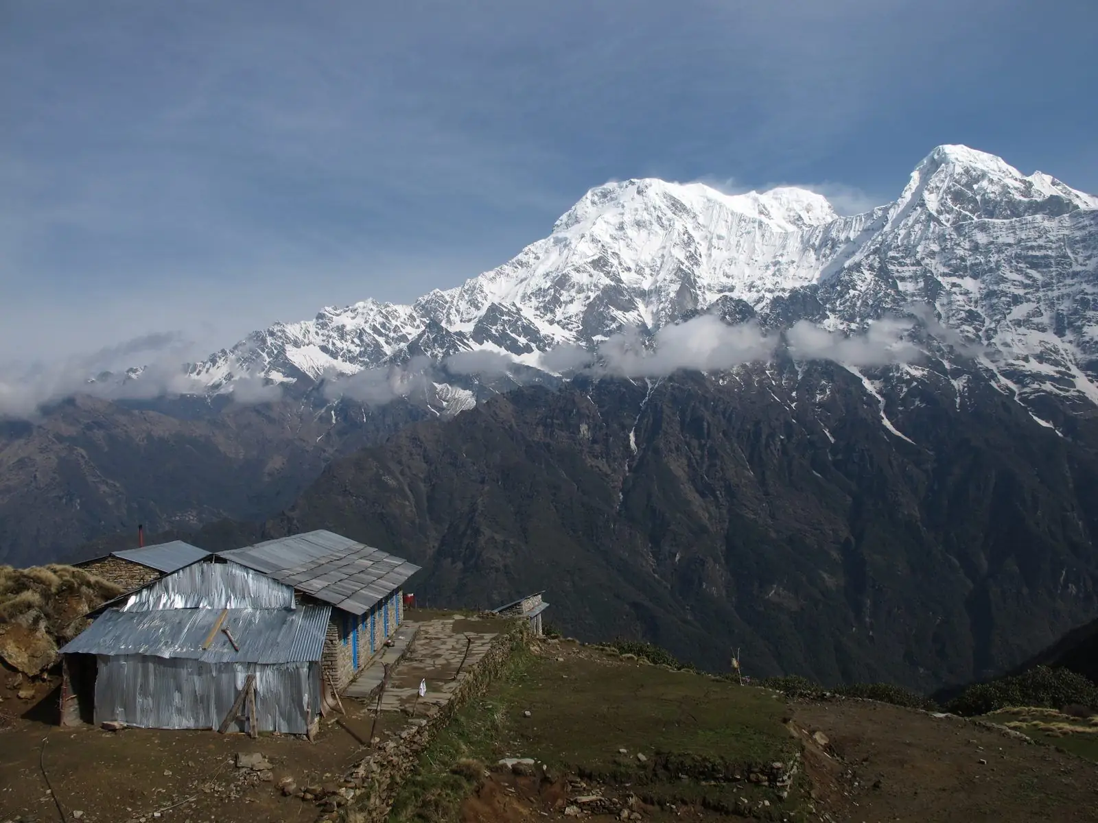 Snow-capped Manaslu range above a tin-roofed hut