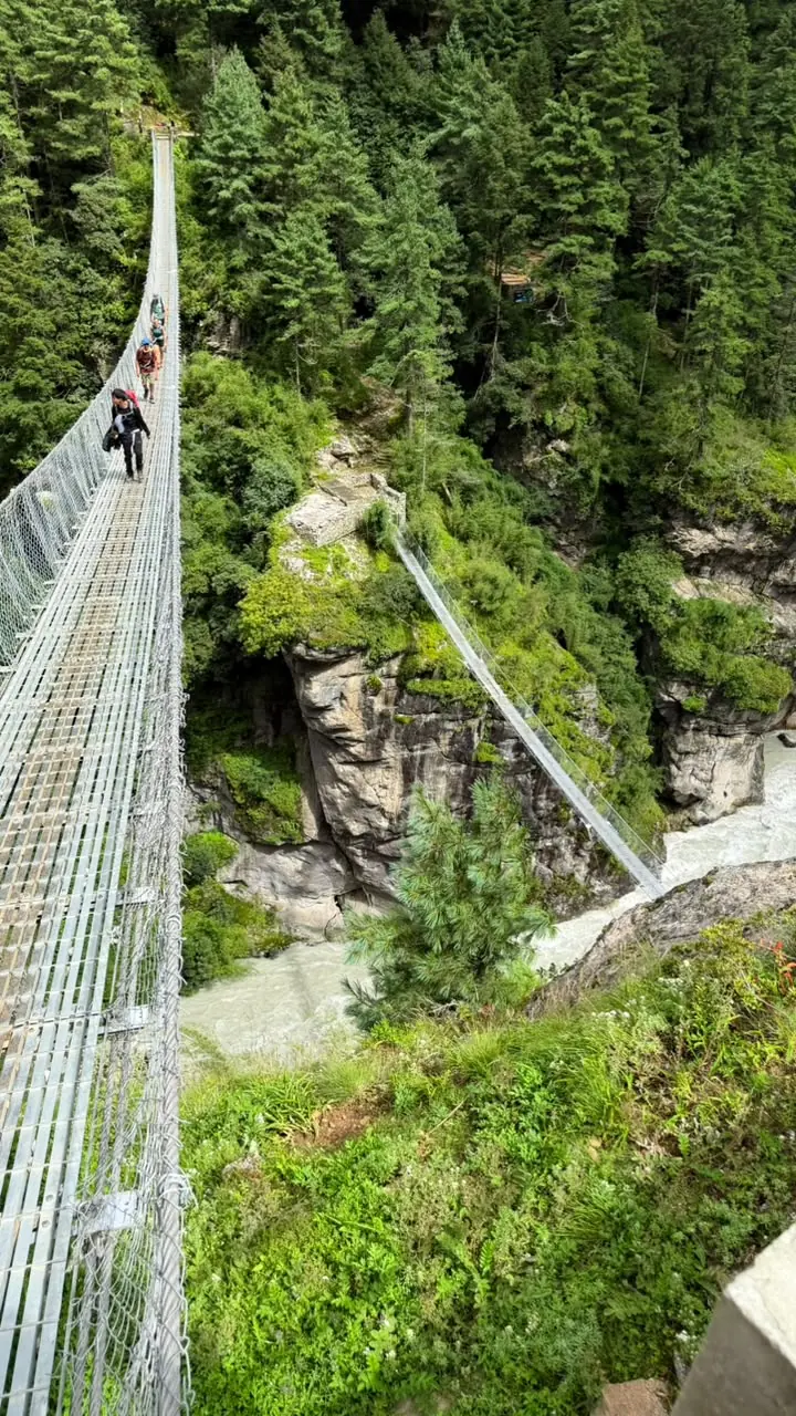 Trekkers crossing a suspension bridge in the Khumbu region